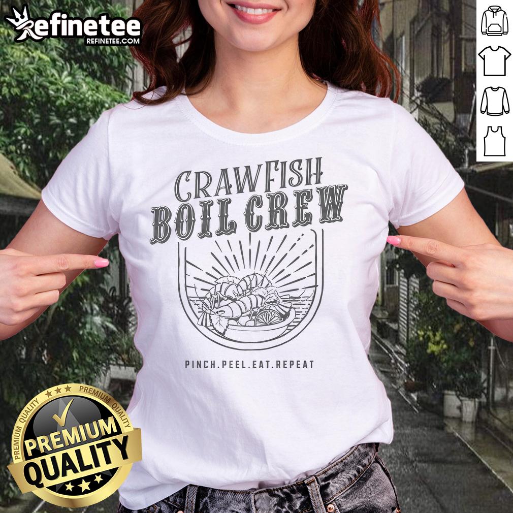 Cheerful women in 'Pinch, Peel, Eat, Repeat' tees enjoying a crawfish boil, showcasing camaraderie and Southern culture.