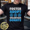 Volunteer in a 'Foster Adopt Donate' T-shirt supporting animal rescue for dogs and cats at a shelter.