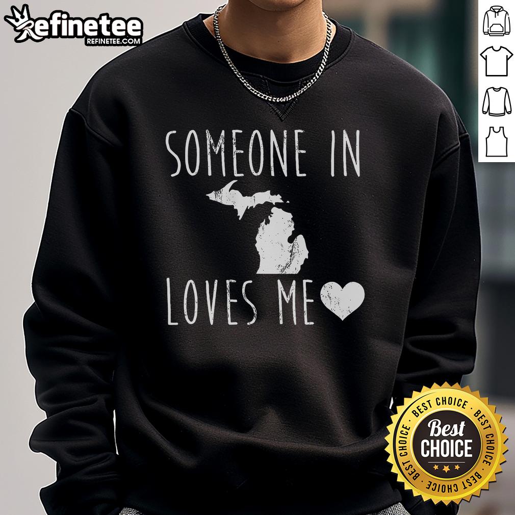 Cozy 'Someone in Michigan State Loves Me' sweatshirt displayed against a rustic backdrop, perfect for fans and gifts.