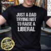 Official Just A Dad Trying Not To Raise A Liberal Premium T-Shirt in black, featuring bold white text for dads.