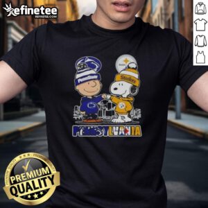 Happy Charlie Brown wearing a Penn State Nittany Lions & Pittsburgh Steelers skyline t-shirt, showcasing team spirit.
