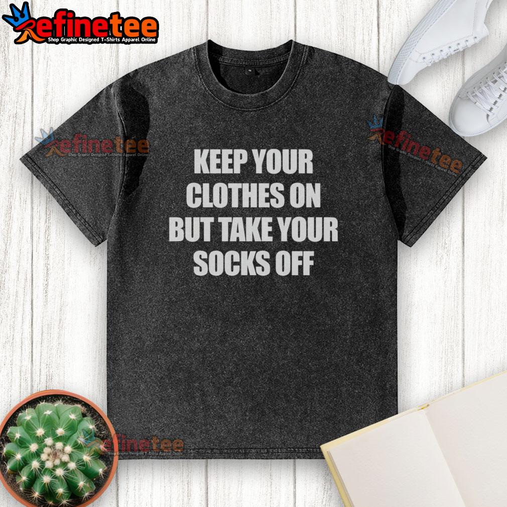 Alt Text: Official Keep Your Clothes On But Take Your Socks Off washed t-shirt displayed on a hanger, showcasing its unique design.