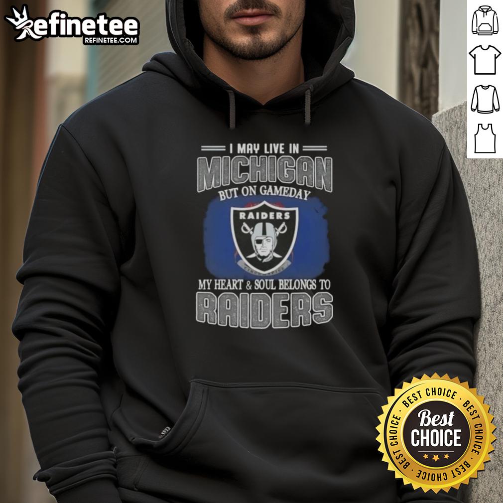 Fan wearing 'Hot I May Live in Michigan But on Gameday My Heart and Soul Belongs to Raiders' hoodie, showing team spirit.