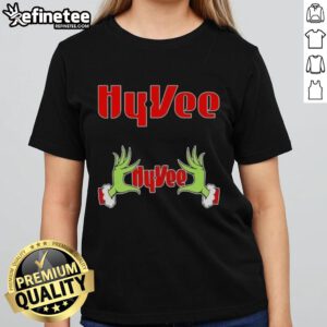 Original Grinch hands holding a heart on a Hy-Vee Christmas ladies tee, perfect for festive holiday celebrations.