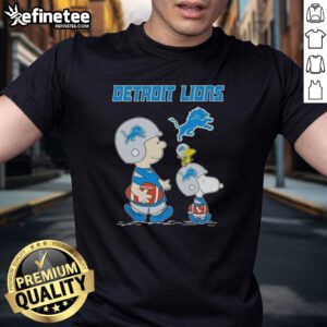 Alt Text: Premium Peanuts Snoopy and Charlie Brown X Detroit Lions football T-shirt featuring vibrant graphics and team colors.