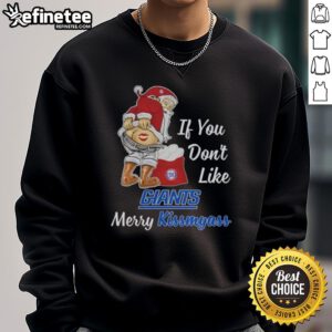 Santa Claus wearing a funny sweatshirt saying 'If You Don't Like New York Giants, Merry Kissmyass' for holiday cheer.