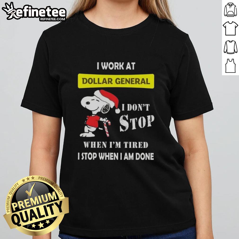 Christmas Ladies Tee featuring Snoopy with the phrase 'I work at Dollar General, I don't stop when I'm tired'.