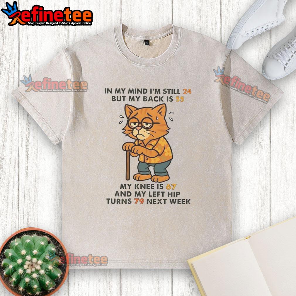 Funny cat washed t-shirt reading 'I'm still 24, but my body feels 55' humorously depicting aging and fitness struggles.