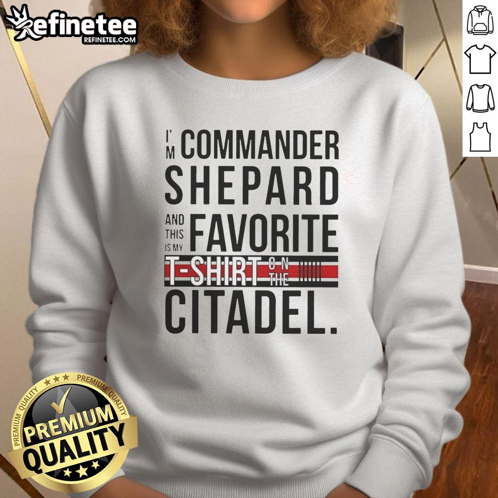 Alt Text: Commander Shepard wearing 'Awesome I'm Commander Shepard' sweatshirt on the Citadel, showcasing iconic Mass Effect style.