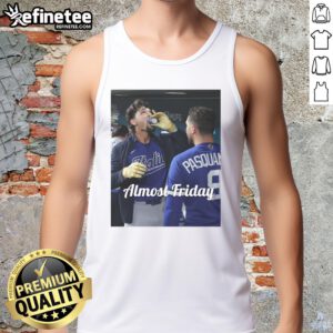 Alt Text: Jac Caglianone of the Kansas City Royals enjoying espresso in dugout zone, wearing Almost Friday tank top.