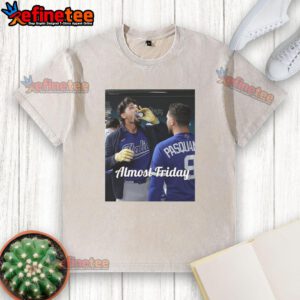 Alt Text: Kansas City Royals' Jac Caglianone enjoying espresso in the dugout, wearing a stylish 'Almost Friday' washed t-shirt.