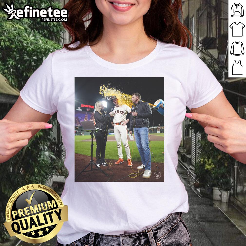 Daniel Susac of the San Francisco Giants celebrates with water thrown on him, wearing a ladies tee, capturing a joyful moment.