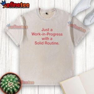 Alt Text: 'Pretty Just A Work In Progress With A Solid Routine washed t-shirt displayed on a hanger, showcasing its casual style.'